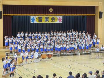 体育館の壇上で合奏をしている児童たちの様子